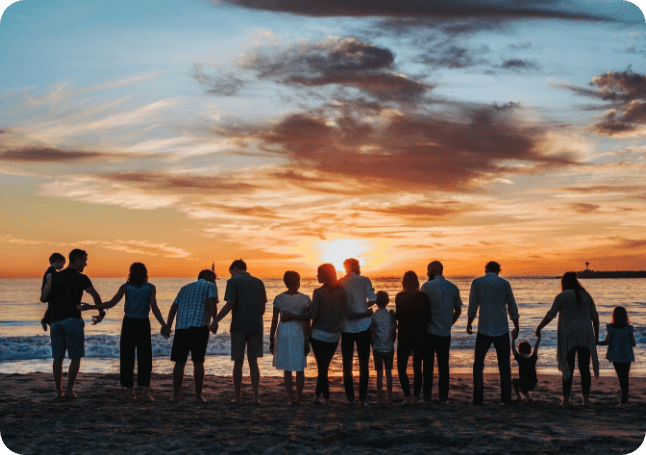 A group of people standing on top of a beach.