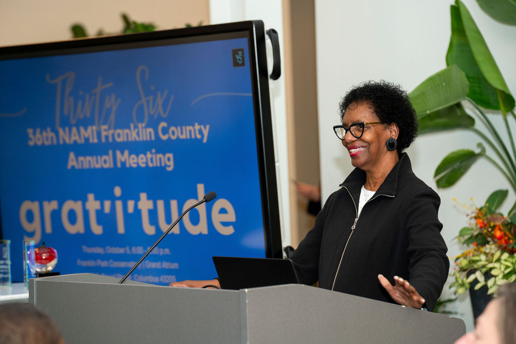 A woman standing at the front of a podium.